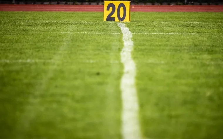 Close-up of a yellow 20-yard line marker on a football field