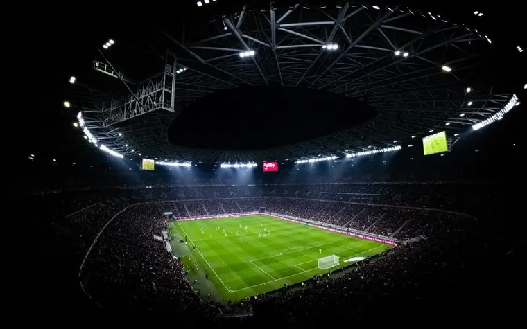 Aerial view of a floodlit soccer stadium at night during a match