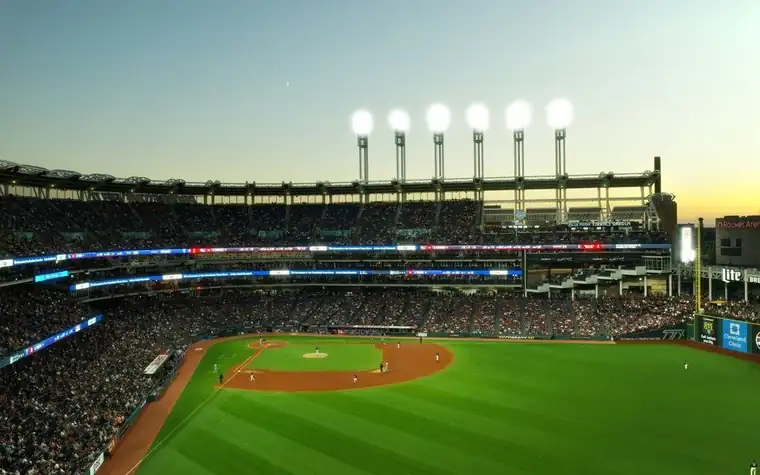 Baseball stadium at dusk with the stadium lights on
