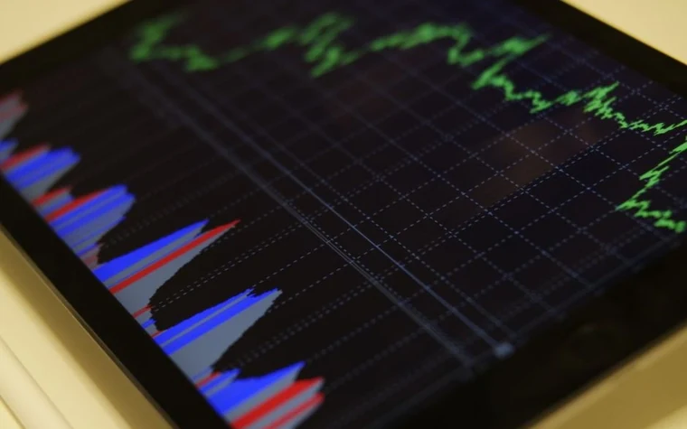 Tablet screen showing a red and blue candlestick price chart