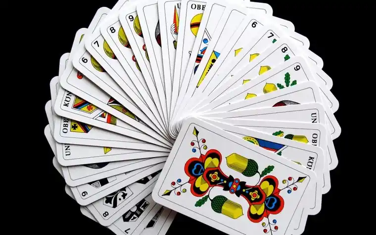 Vibrant playing cards fanned out in a wide arc against a dark background