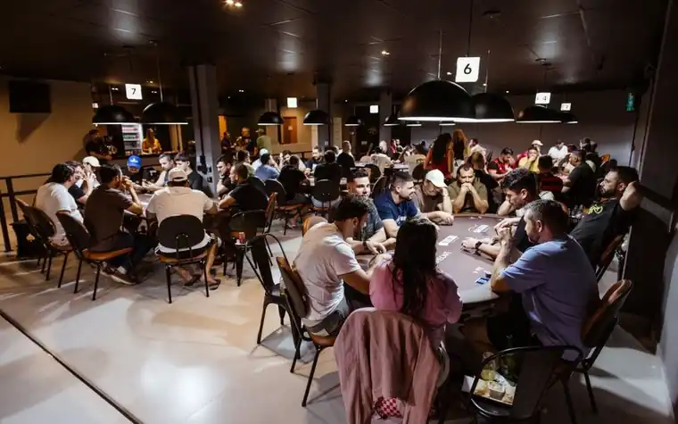 A group of players seated around a casino table during a hand of poker