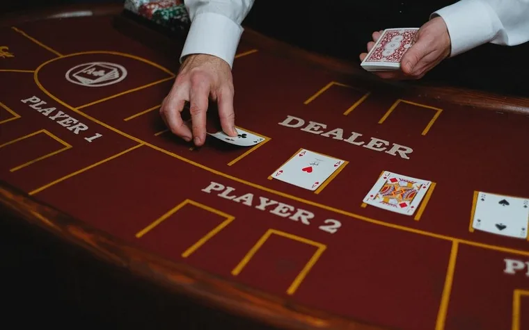 A casino dealer dealing cards at a felt table marked Player 1, Player 2, and Dealer