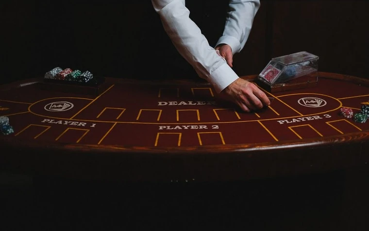 Croupier dealing cards at a dimly lit casino table