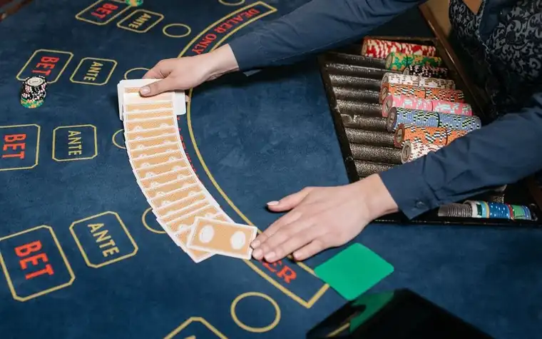 Casino dealer spreading playing cards on the table