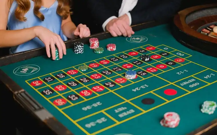 Players placing bets at a casino roulette table