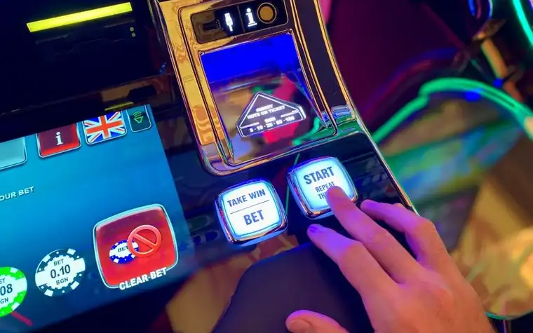 Hand pressing buttons on a slot machine