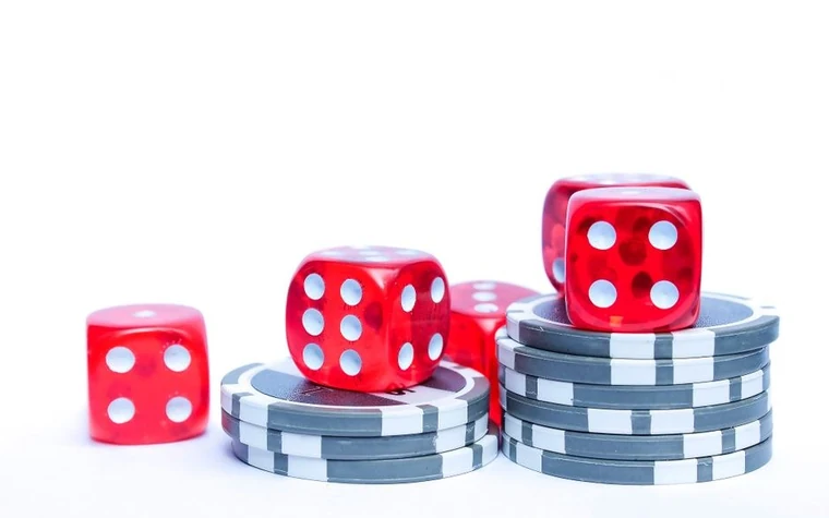 Red dice stacked on top of casino chips