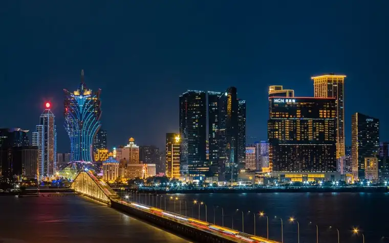 Macau skyline at night with illuminated towers reflected across the harbour