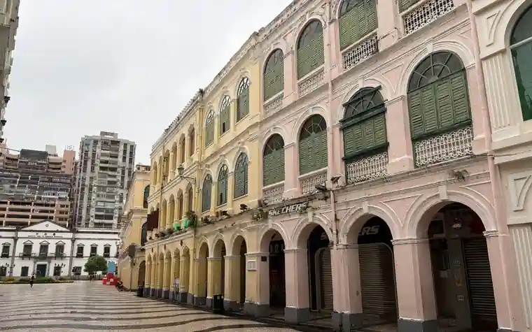 Pastel colonial buildings lining a paved square in Macau's historic centre