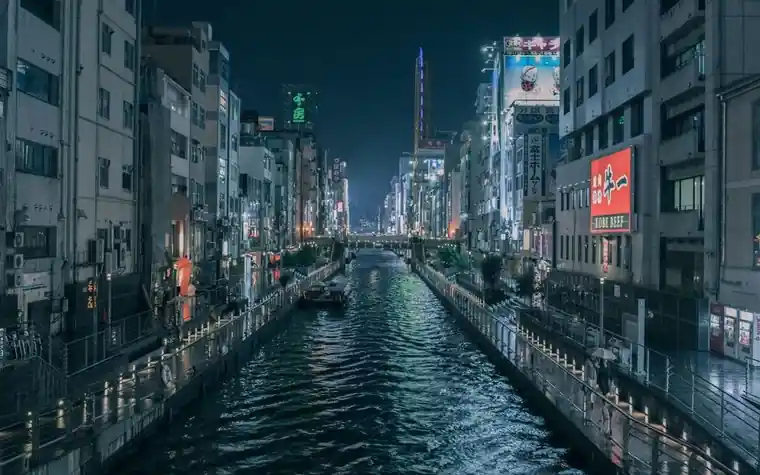 Illuminated Dotonbori canal in Osaka lined with neon signs at night