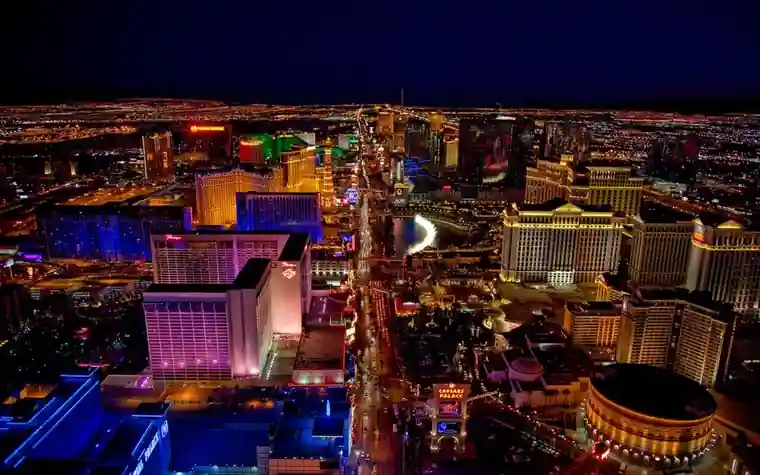 Aerial night view of the Las Vegas Strip with illuminated hotel towers along the boulevard