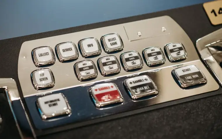 close-up of silver and red buttons on the control panel of a casino gaming machine