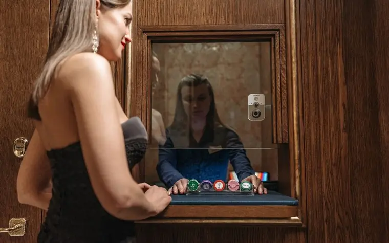 Woman at a casino cashier counter receiving stacked chips