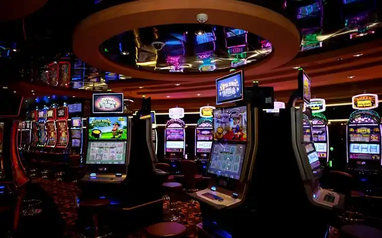 Casino floor lined with brightly lit slot machines