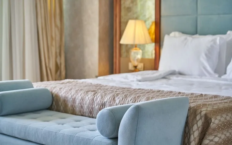 Elegant hotel bedroom with a plush white bed and upholstered seating area