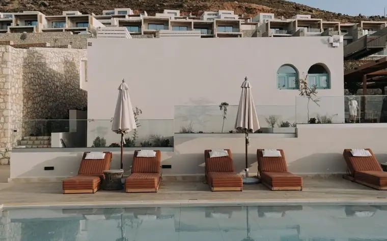 Luxury resort poolside with lounge chairs and umbrellas beside the pool