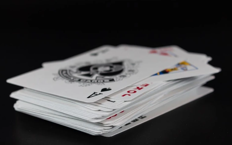 Stack of playing cards fanned out with an ace of spades visible on top