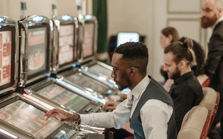 Group of casino guests playing slot machines together in the evening